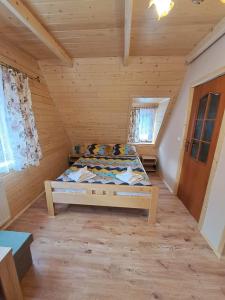 een slaapkamer met een bed in een houten kamer bij Dworek na skraju lasu in Kościelisko
