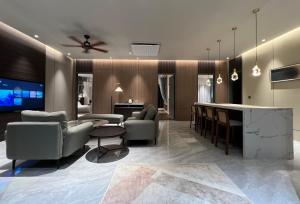 a living room with couches and a tv and a table at Looma Private Pool Villas in Pantai Cenang +30 photos