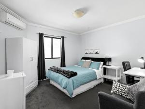 a bedroom with a bed and a couch at Sunny Rooms Mascot in Sydney