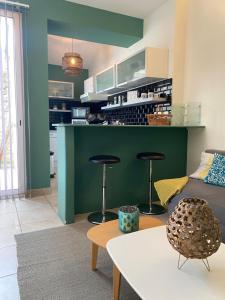 a living room with a green counter and two stools at Le Loft PATIO, au coeur du village in Saint-Rémy-de-Provence