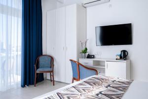 - une chambre avec un lit, un bureau et une télévision dans l'établissement Gillieru Harbour Hotel, à San Pawl il-Baħar