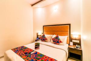 a hotel room with a bed with a colorful blanket at FabHotel Admiral in Mumbai
