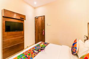 a bedroom with a bed and a flat screen tv at FabHotel Admiral in Mumbai