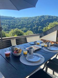 une table bleue avec des assiettes et des bols de nourriture dans l'établissement Les 3 Frères : plain-pied en pleine nature, à Vresse-sur-Semois