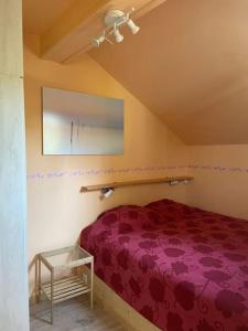 - une chambre avec un lit violet et une table dans l'établissement Les 3 Frères : plain-pied en pleine nature, à Vresse-sur-Semois