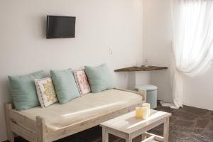 a living room with a couch and a tv at Scorpios Hotel & Suites in Samos