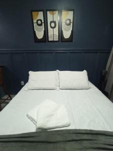 Una cama blanca con tres cuadros en la pared en FLAT - 200m da orla do Bessa, en João Pessoa