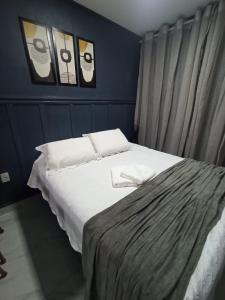 1 cama en un dormitorio con 2 cuadros en la pared en FLAT - 200m da orla do Bessa, en João Pessoa