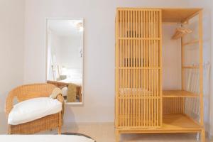 Habitación con estantería de madera y espejo. en Budget Beach Studio 22, en Sant Antoni de Calonge