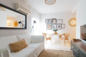 sala de estar con sofá blanco y mesa en Budget Beach Studio 22, en Sant Antoni de Calonge