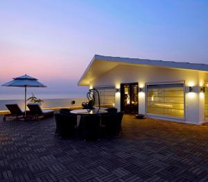 een gebouw met een tafel en stoelen en een paraplu bij Sun-n-Sand Mumbai Juhu Beach in Mumbai