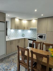 cocina con mesa de madera, mesa y sillas en La casa del barrio en Mijas