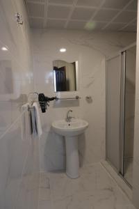 a white bathroom with a sink and a shower at SALİH BEY KONAĞI in Amasya