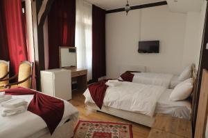 a hotel room with two beds and a mirror at SALİH BEY KONAĞI in Amasya