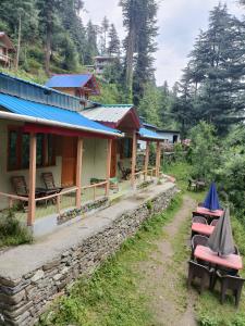 a group of chairs sitting outside of a building at Reverberate Cafe & Cottages - Negi's Place in Jibhi