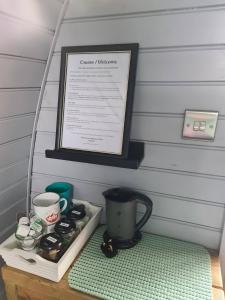 a table with a coffee maker and a sign on it at Delightful Camping Pod in Snowdonia, North Wales. in Derwen