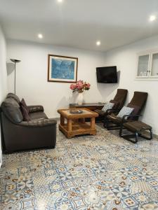 a living room with couches and a table and a tv at La casa del barrio in Mijas