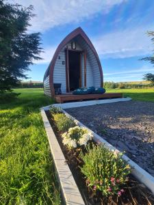 a tiny house in the middle of a field at Delightful Camping Pod in Snowdonia, North Wales. in Derwen
