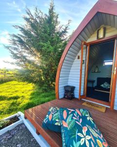 a bed sitting on a porch of a shed at Delightful Camping Pod in Snowdonia, North Wales. in Derwen