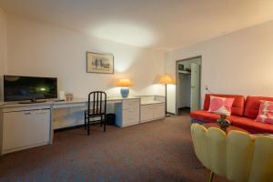 a living room with a couch and a flat screen tv at Hessenland Hotel Kassel Innenstadt by Stay Awesome in Kassel