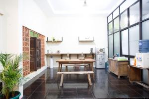 Habitación con mesa y cocina con ventanas. en Rumah Kalpataru, en Yogyakarta