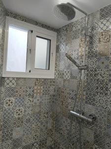 a bathroom with a shower with a window at La casa del barrio in Mijas