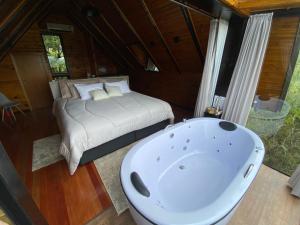 um quarto com uma cama e uma banheira em Morada Alto Das Nuvens em São José dos Ausentes