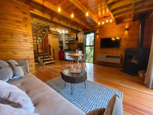 a living room with a white couch and a fireplace at Morada Alto Das Nuvens in São José dos Ausentes