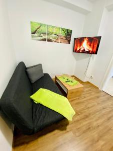uma sala de estar com um sofá preto e uma lareira em Abschalten im Zentrum von Bad Ischl em Bad Ischl
