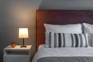 a bedroom with a bed with a lamp on a night stand at Athenian center apartments in Athens