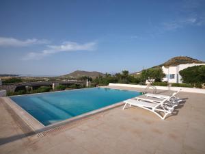 a swimming pool with two lounge chairs and a swimming pool at Nola Traditional Villa with pool and amazing sea views, Paros in Kampos Paros