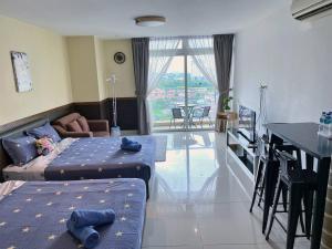a room with two beds and a table and a kitchen at KSL D'Esplanade Apartment Suites by SC Homestay in Johor Bahru