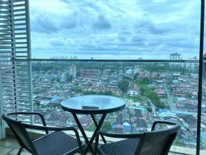 a table and chairs on a balcony with a city view at KSL D'Esplanade Apartment Suites by SC Homestay in Johor Bahru