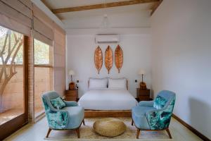 sypialnia z łóżkiem i 2 krzesłami w obiekcie O2 Villas Yala w mieście Yala