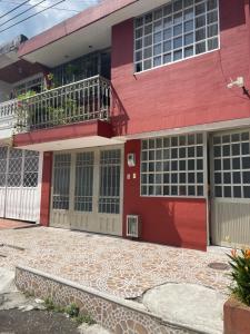 Casa roja con puerta roja y balcón en Casa de Descanso Marrón 101, en Villavicencio