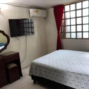 1 dormitorio con 1 cama y TV de pantalla plana en Casa de Descanso Marrón 101, en Villavicencio