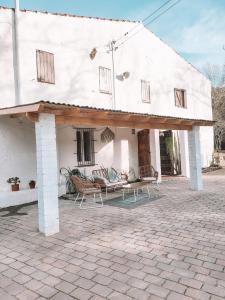 a white house with a patio with chairs and a table at Casa Om in Dosríus