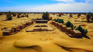 une vue aérienne sur un désert avec un bâtiment dans l'établissement Camp Sahara Majestic, à M'Hamid El Ghizlane