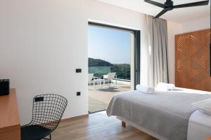 a bedroom with a bed and a view of a balcony at Villa Anasa in Palaiochóra +48 photos