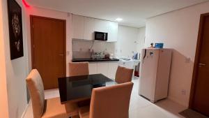 eine Küche mit einem Tisch und Stühlen sowie einem Kühlschrank in der Unterkunft AP studio805 in Maceió