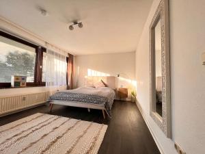 1 dormitorio con cama y espejo grande en Exclusive Maisonette 90qm Parkplatz Balkon Citynah, en Seevetal