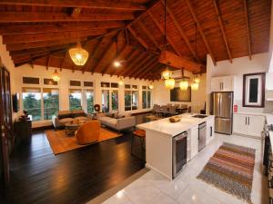 a large kitchen and living room with wooden ceilings at Casa Varuna - 3 Bedrooms in West End