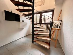 a spiral staircase in a room with a tv at Exclusive Maisonette 90qm Parkplatz Balkon Citynah in Seevetal