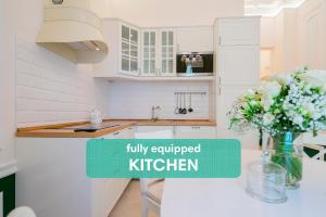 a kitchen with a vase of flowers on a counter at Revelton Suites Karlovy Vary in Karlovy Vary