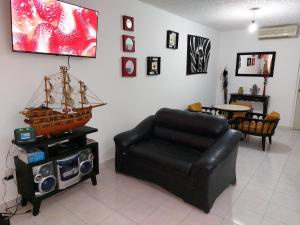 a living room with a leather couch and a table at Casa Acá Diamante Gaviotas in Acapulco