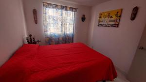 a red bed in a bedroom with a window at Casa Acá Diamante Gaviotas in Acapulco +5 photos