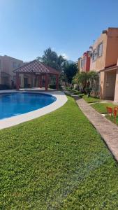 a yard with a swimming pool and a gazebo at Casa Acá Diamante Gaviotas in Acapulco