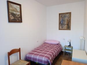 a small bedroom with a bed and a table at Appartamento Primo Sole in Primaluna