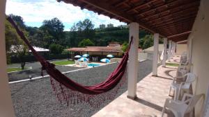 a hammock on a house with a view of a pool at Pousada Saint James in Águas de Lindóia