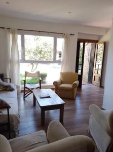 Sala de estar con sofás y mesa de centro en Amplia casa con parque y pileta en Olavarría